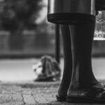 a black and white photo of a person standing on a sidewalk
