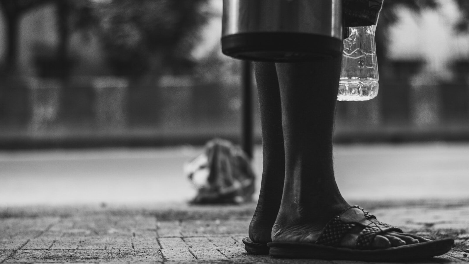 a black and white photo of a person standing on a sidewalk